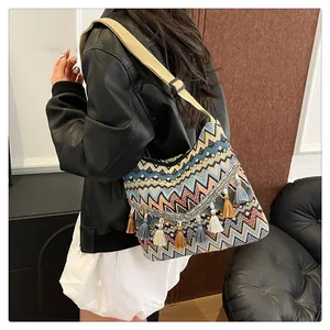 Detail view of large bohemian crossbody bag with colorful geometric patterns and fringe