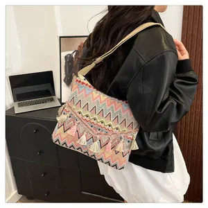 Bohemian crossbody bag with colorful zigzag patterns and tassels shown on a model