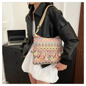 Close-up of bohemian shoulder bag with colorful geometric patterns and fringe tassels