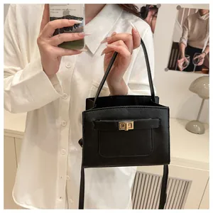 Dettaglio della borsa in pelle saffiano nera con elegante chiusura a scatto dorata