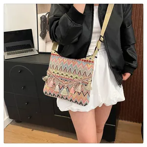 Detail of colorful ethnic crossbody bag with wavy patterns and V-shaped fringe tassels