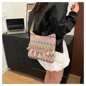 Detailed close-up of a colorful woven ethnic shoulder bag with vibrant tassel charms