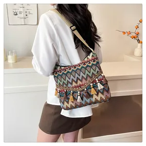Close-up of bohemian woven shoulder bag featuring colorful zigzag patterns and tassels