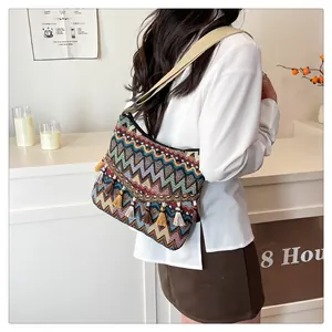 Detail of bohemian shoulder bag featuring colorful zigzag patterns and long fringe tassels