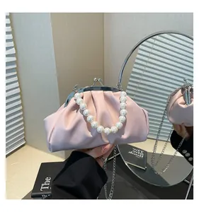 Detail showing pink pleated cloud bag with white pearl handle and silver metal chain