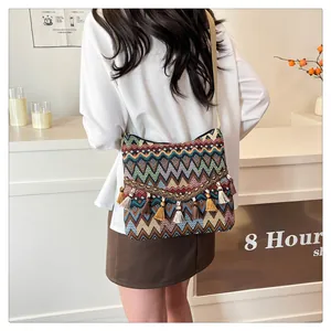 Detail of colorful geometric woven bag with bohemian tassels and beaded fringe decor