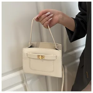 Dettaglio borsa a mano color crema in pelle con chiusura girevole dorata e tasca