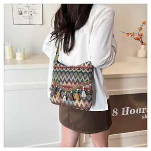 Detail of bohemian woven bag with colorful zigzag patterns and hanging tassel fringe