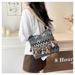 Close-up of bohemian shoulder bag featuring zigzag patterns and colorful tassels