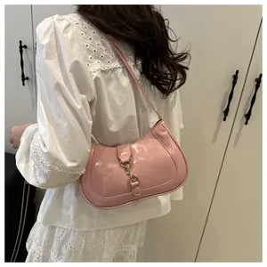 Detail of pale pink patent leather crescent bag with gold-tone metal hook buckle