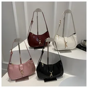 Detail shot of vintage leather baguette bags in wine red, white, pink, and black