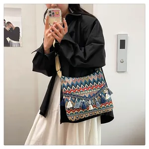Ethnic shoulder bag detail showing colorful woven geometric patterns and blue fringe trim