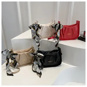 Détail de sacs à bandoulière plissés en quatre couleurs avec foulards en soie décoratifs