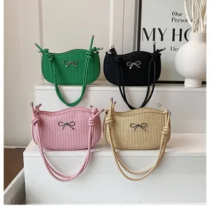Vier gewebte Handtaschen mit Schleifen in Grün, Schwarz, Rosa und Beige in der Detailansicht
