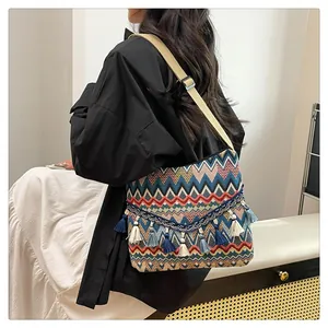 Detailed close-up of Bohemian woven shoulder bag with colorful wave patterns and fringe decor