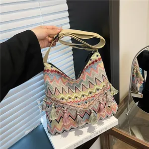 Bohemian style woven shoulder bag with colorful geometric patterns and tassel charm