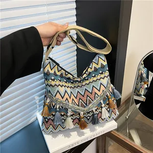 Bohemian woven shoulder bag with colorful zigzag patterns and multi-colored fringe
