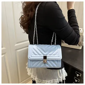 Detail of light blue quilted chain strap shoulder bag with silver twist lock on model
