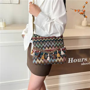 Ethnic bohemian woven crossbody bag with colorful zigzag patterns and tassel charms