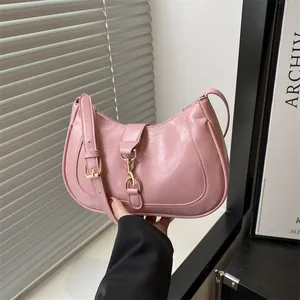 Pink PU leather baguette bag with metal buckle shown in a stylish lifestyle setting
