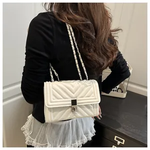 Detail of white V-quilted shoulder bag with elegant metal chain strap and square lock