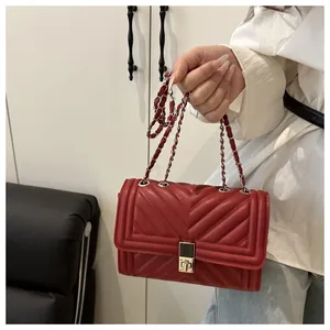 Close-up of red quilted texture and silver chain strap on a rectangular shoulder bag