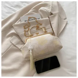 Dettaglio borsa jacquard floreale con ciondolo di nappe di perle e manico in metallo