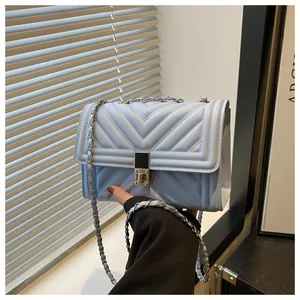 Close-up of light blue chevron quilted leather bag with elegant metal chain strap