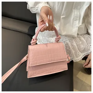 Détail d'un sac à main rose à motif crocodile avec poignée à nœud en cuir PU poli