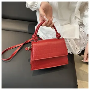 Détails macro de la texture crocodile rouge et de la poignée nouée sur le sac à main