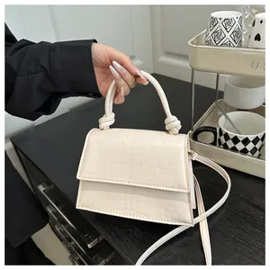 Détail du sac bandoulière blanc crème avec relief crocodile et poignée nouée