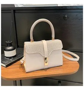 Makro-Detail der cremeweißen Handtasche mit funkelnden Strasssteinen und goldenem Drehverschluss
