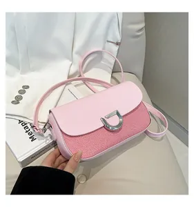 Dettaglio di una borsa rosa con trama a righe e fibbia in metallo argentato a forma di D
