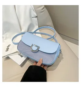 Dettaglio della borsa a tracolla azzurra con chiusura a U argento e trama intrecciata