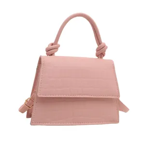 Mini sac à main rose effet crocodile avec poignée nouée et bandoulière sur fond blanc