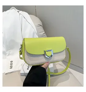 Dettaglio di pelle verde lime e tela beige con fibbia metallica a ferro di cavallo argento