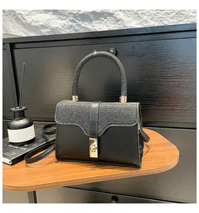 Detail der schwarzen Paillettenhandtasche mit goldenem Drehverschluss und Leder