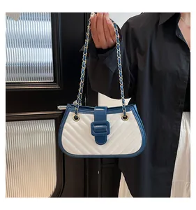 Détail du sac matelassé blanc avec bordure bleu marine et chaîne dorée