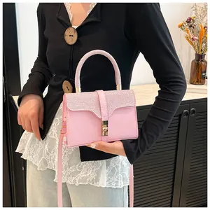 Rosa Handtasche mit Glitzergriff und Goldverschluss, stilvoll in der Hand gehalten