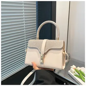 Elegante cremefarbene Lederhandtasche mit glitzernden Strasssteinen und goldenem Drehverschluss