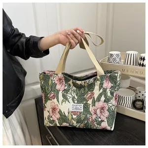 Detailed macro view of the floral jacquard fabric and cream webbing handle on canvas tote