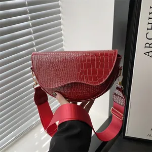 Red crocodile embossed half-moon saddle bag with wide fabric shoulder strap for women