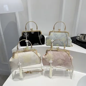 Close-up of vintage shell bags with floral embroidery, metal handles and long tassels