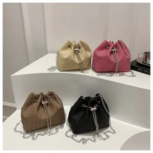 Detail of corduroy bucket bags with silver chain and dual pearl drawstring accents