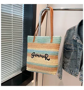 Détail d'un sac cabas en paille tissée avec broderie Summer et motif à rayures colorées