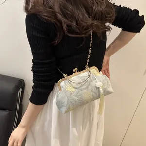 Detail of grey vintage shell bag with gold flower embroidery and long elegant tassel