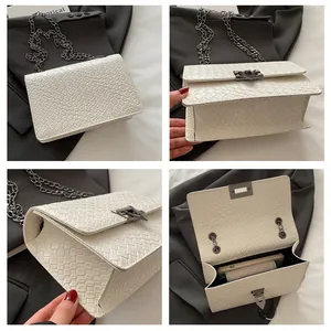 Detalle de bolso blanco con cadena mostrando textura de piedra y el espacio interior amplio