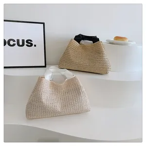 Detail of woven straw tote bags with silk handles in cream and beige colors