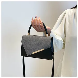 Sac à main chic patchwork noir et gris avec barre dorée et poignée circulaire