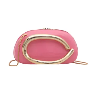Modern fuchsia round crossbody bag with large golden C-handle and metallic chain strap